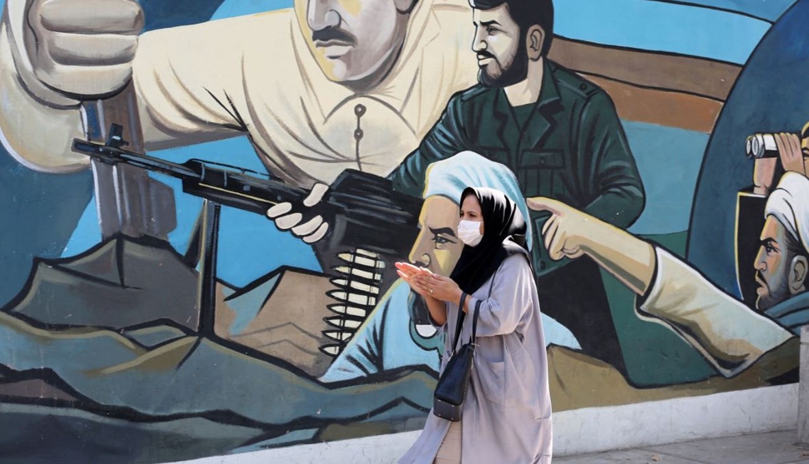 امرأة تمر بالقرب من لوحة جدارية في ساحة فلسطين في طهران (18  2020، أ ف ب). 