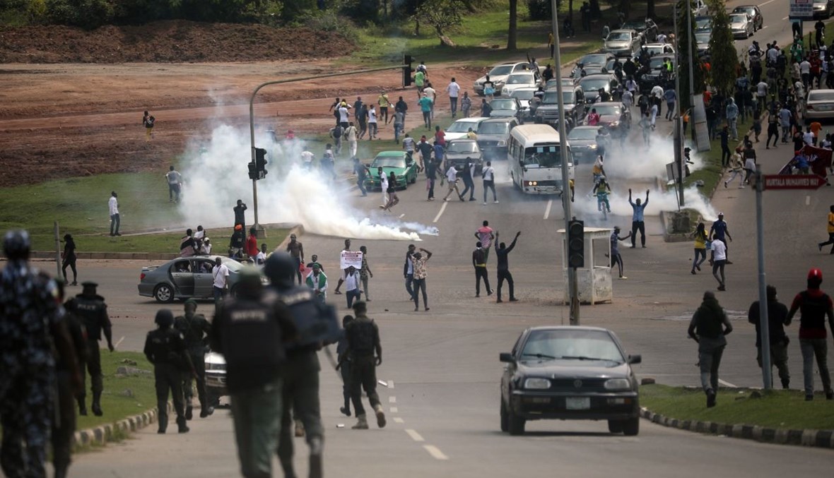 الشرطة النيجيرية تطلق الغاز المسيل للدموع على متظاهرين على طريق أبوجا- كفي السريع في أبوجا بنيجيريا (19 ت1 2020، أ ف ب). 