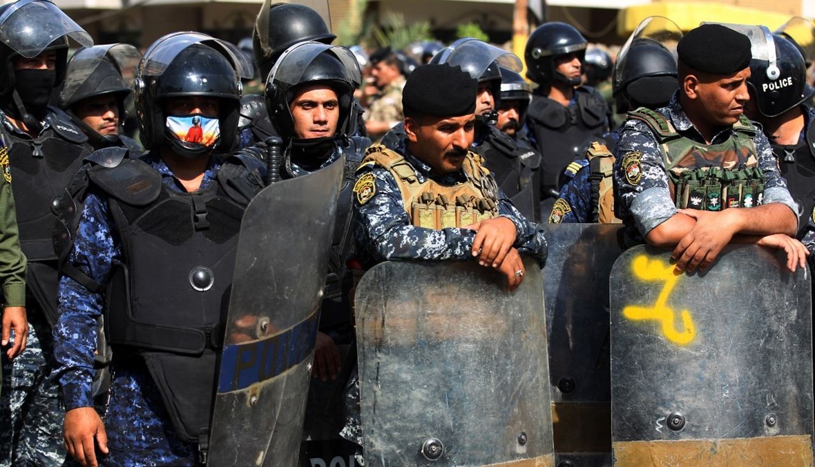 عناصر من قوات الأمن العراقية في مواجهة متظاهرين من أنصار الحشد الشعبي وهم يقتحمون مقر الحزب الديمقراطي الكردي في العاصمة بغداد (17 ت1 2020، أ ف ب). 