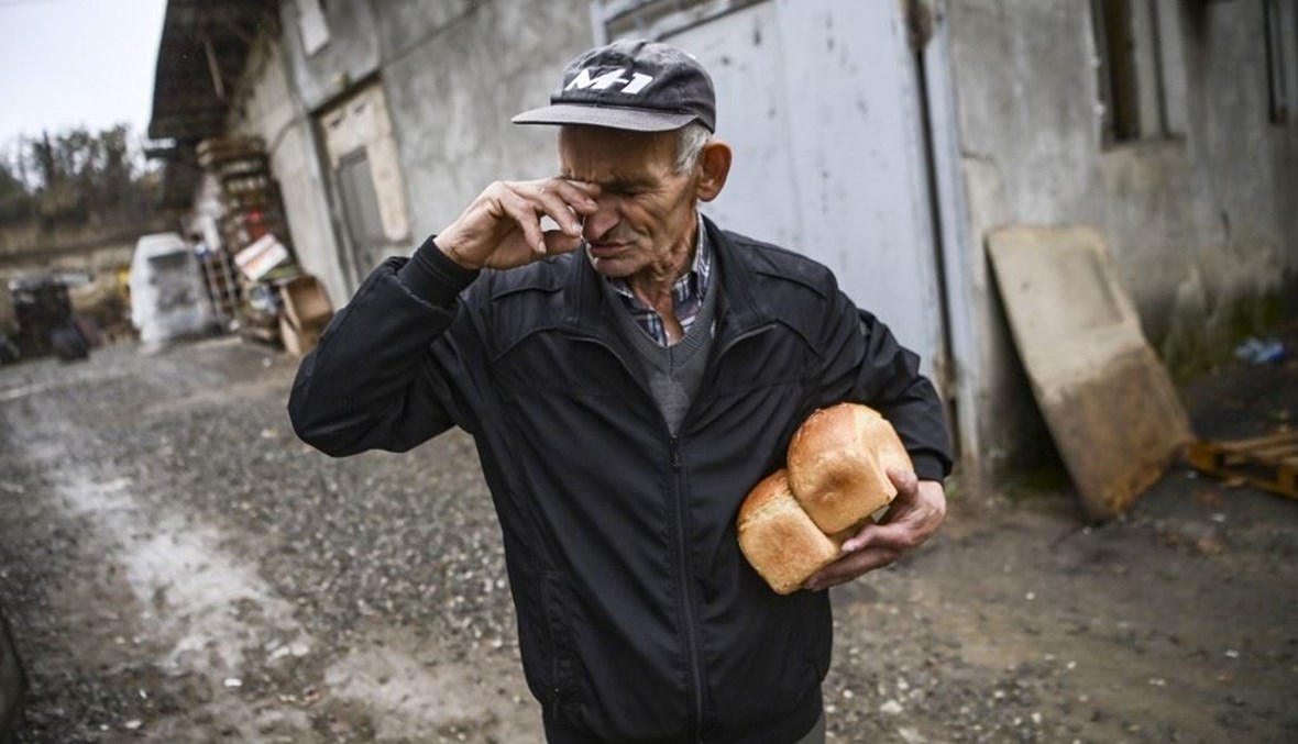 رجل يحمل خبزاً في أحد شوارع مدينة ستيباناكيرت بإقليم كراباخ أمس.   (أ ف ب)