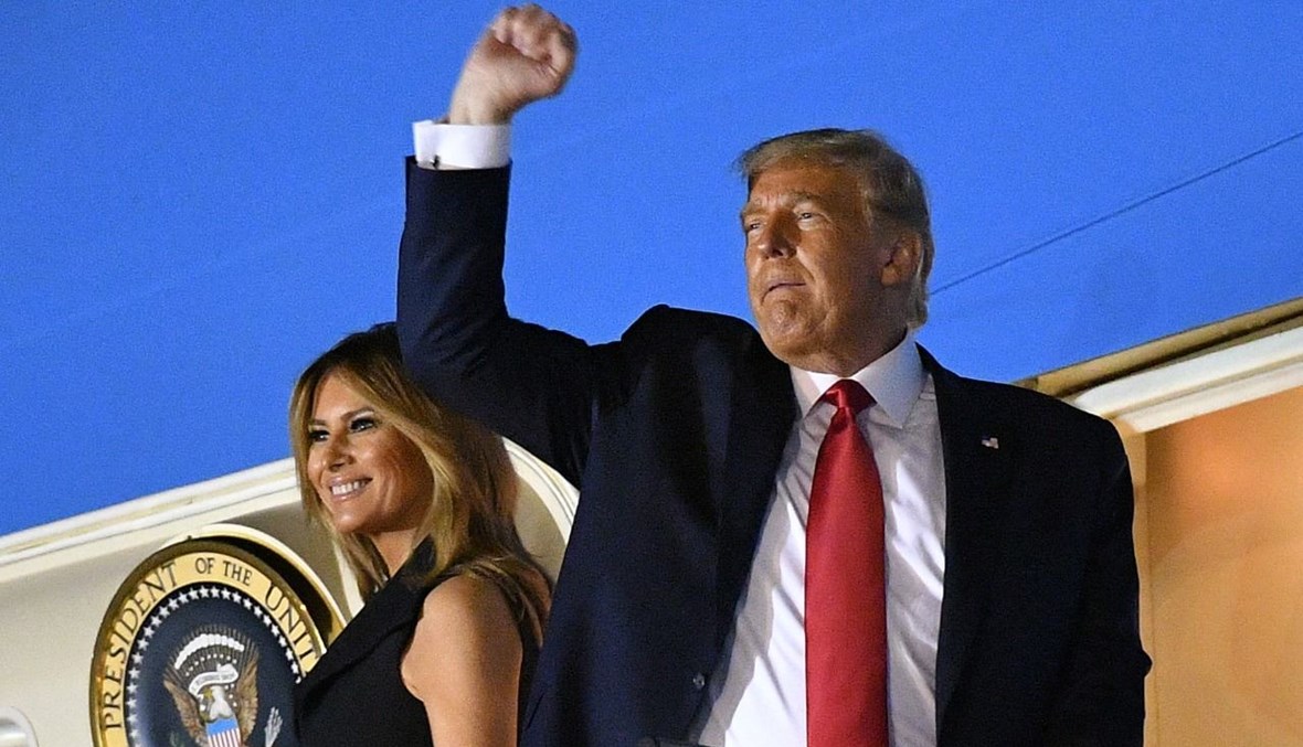 ترامب يرفع قبضته بينما يصعد برفقة زوجته ميلانيا الى طائرة الرئاسة لمغادرة مطار ناشفيل الدولي بعد المناظرة الرئاسية في ناشفيل بتينيسي (22 ت1 2020، أ ف ب).