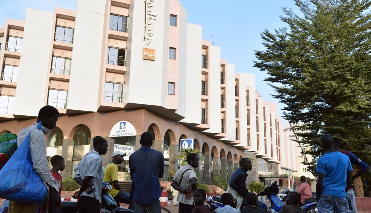 أشخاص يقفون خارج فندق راديسون بلو في باماكو، بعد يوم على الهجوم عليه (21 ت2 2015، أ ف ب). 