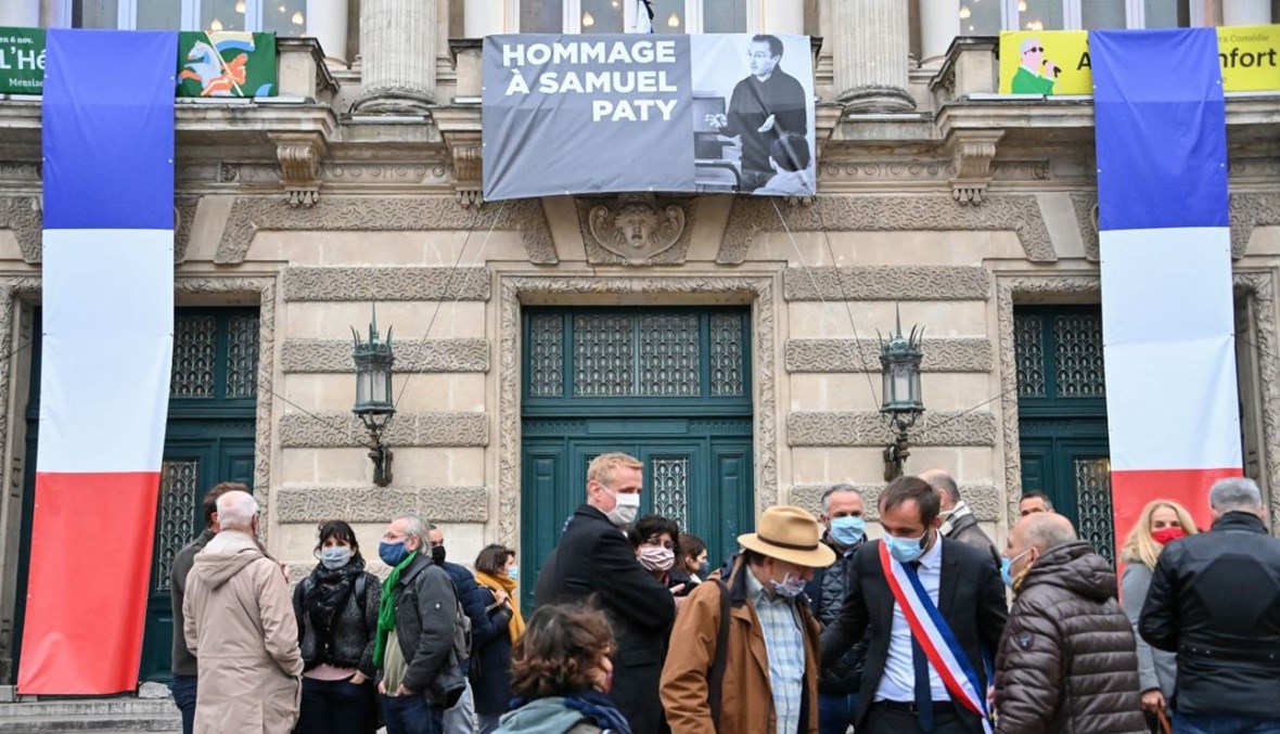 أشخاص تجمعوا أمام "أوبرا كوميدي" في مونبلييه، حيث رفعت اعلى المبنى صورة لباتي خلال تكريم وطني له (21 ت1 2020، أ ف ب).  