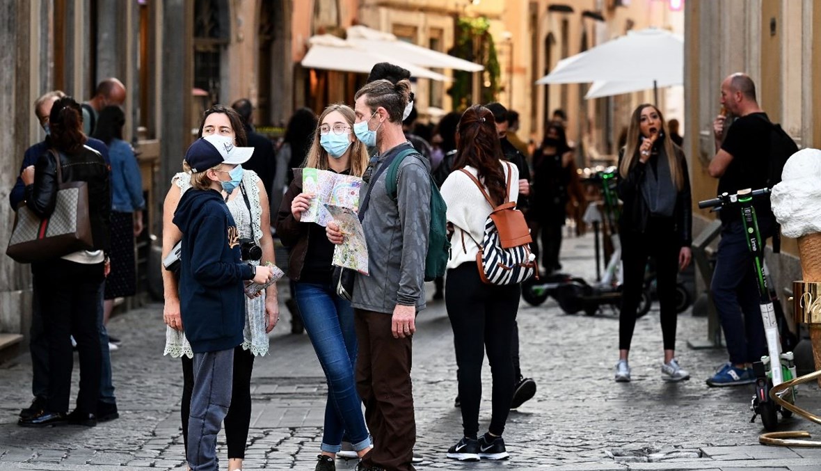 مواطنون إيطاليون وسياح يمشون قي وسط مدينة روما (25 ت1 2020، أ ف ب). 
