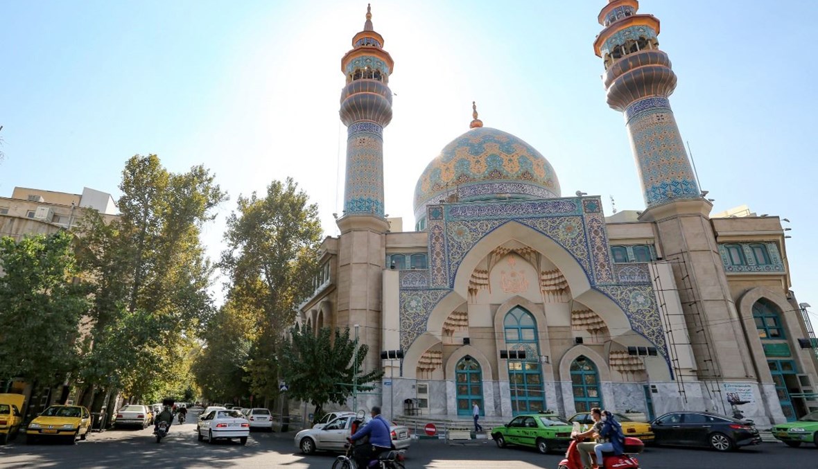 سيارات تمر بالقرب من مسجد الإمام صادق في ساحة فلسطين في طهران (18 ت1 2020، أ ف ب). 