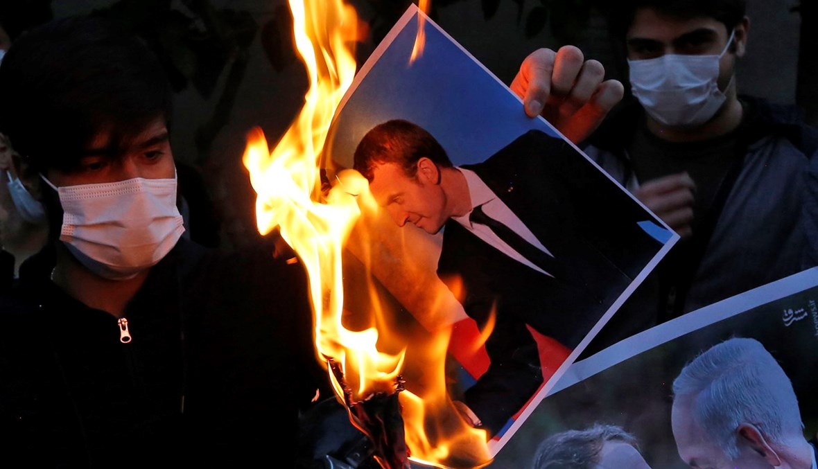 إحراق صورة الرئيس الفرنسي إيمانويل ماكرون أمام السفارة الفرنسية في طهران (أ ف ب).
