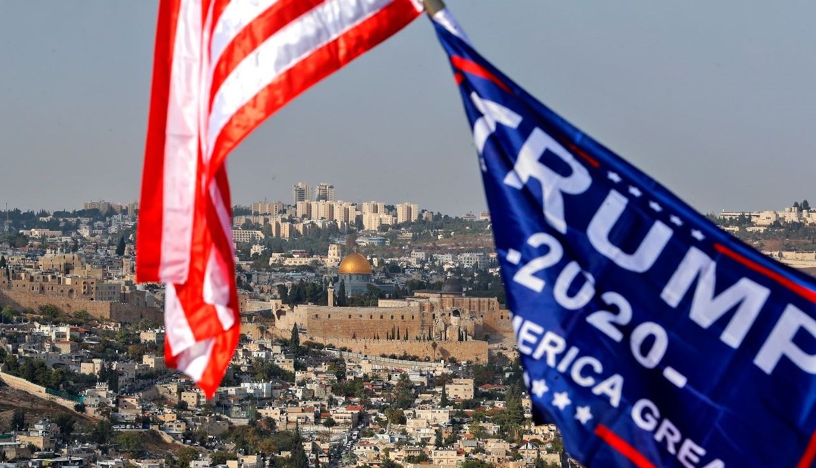 علم اميركي مع علم حملة ترامب يرفرفان في القدس. وبدت مدينة  القدس في الخلفية (27 ت1 2020، أ ف ب). 