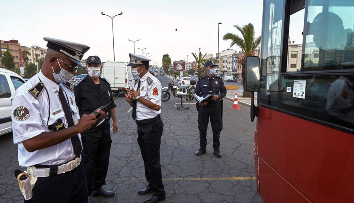 شرطيون يدققون في السيارات عند نقطة تفتيش في الدار البيضاء  بالمغرب (21 أيلول 2020، أ ب). 