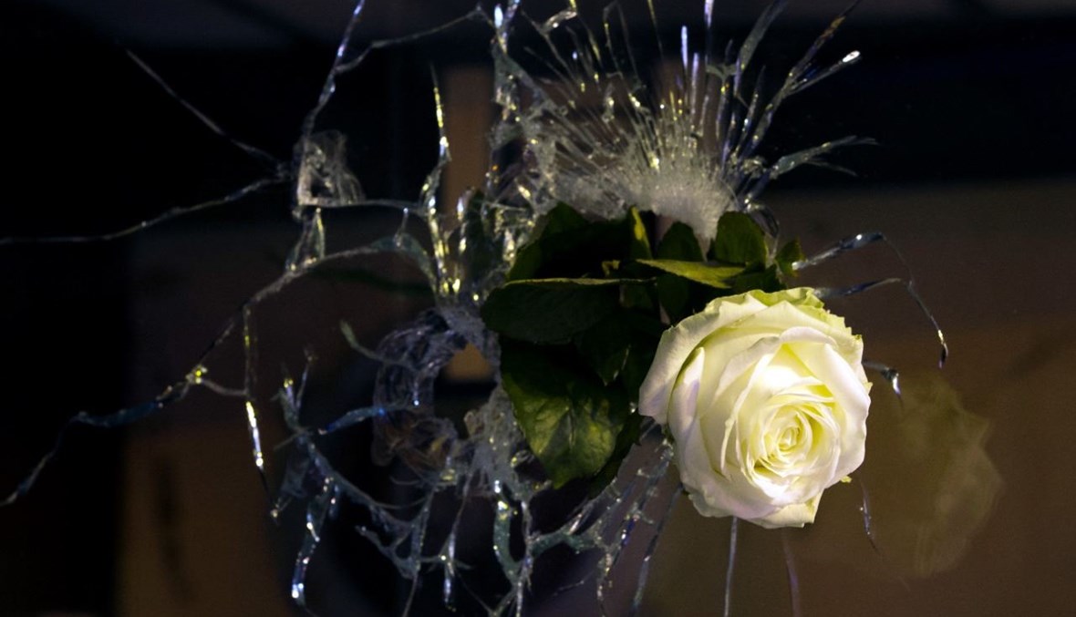 وردة بيضاء وضعت في ثقب أحدثته رصاصة في نافذة في شارع دي شارون في باريس (14 ت2 2015، أ ف ب). 