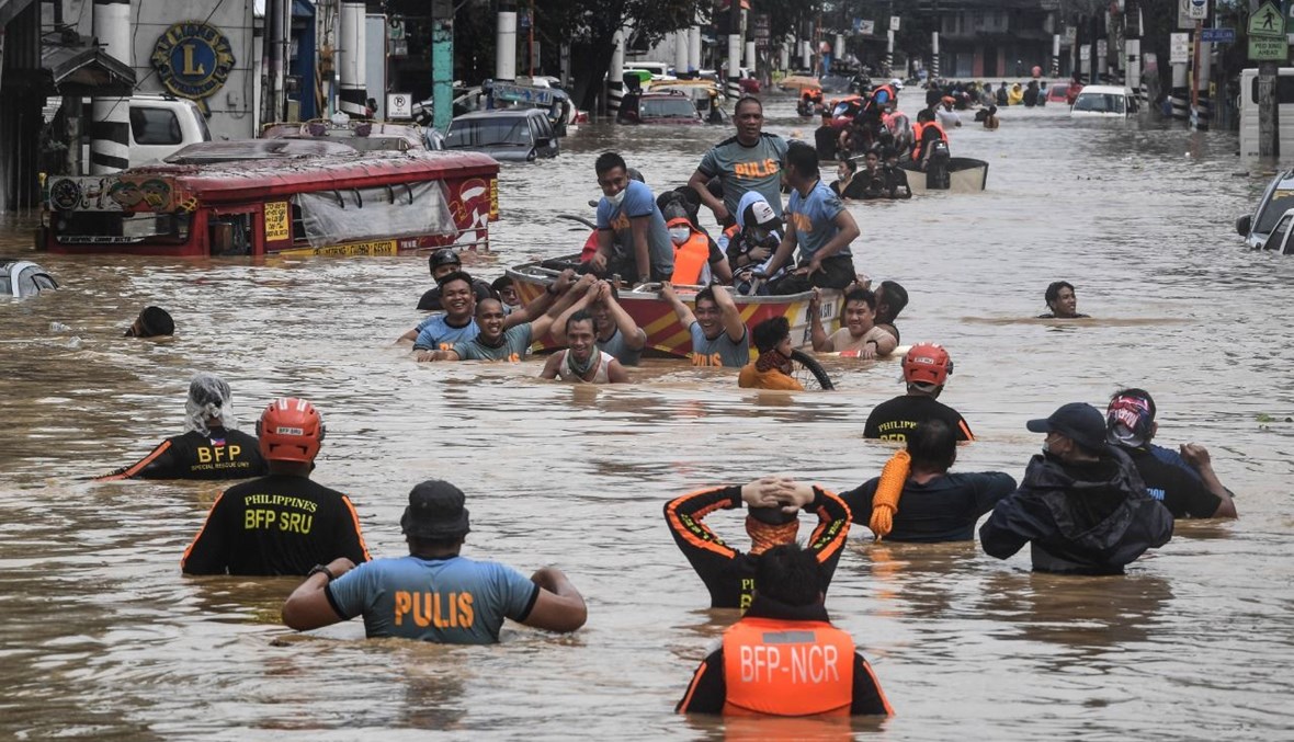نقل سكان في زوارق إنقاذ في مدينة ماريكينا، بعدما غرقت الشوارع في المياه (12 ت2 2020، أ ف ب). 