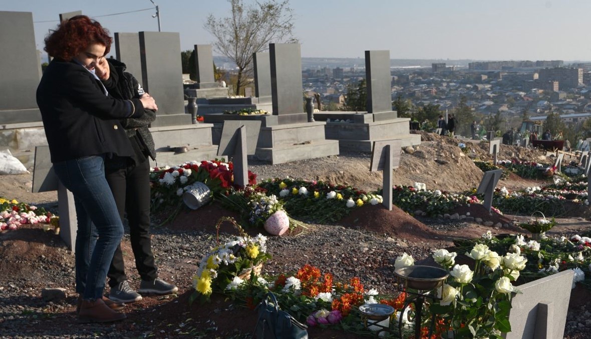امرأتان تبكيان عند قبر جندي أرميني في مقبرة يرابيل التذكارية العسكرية في يريفان، بعد مقتله خلال الصراع العسكري بين أرمينيا وأذربيجان (14 ت2 2020، أ ف ب). 