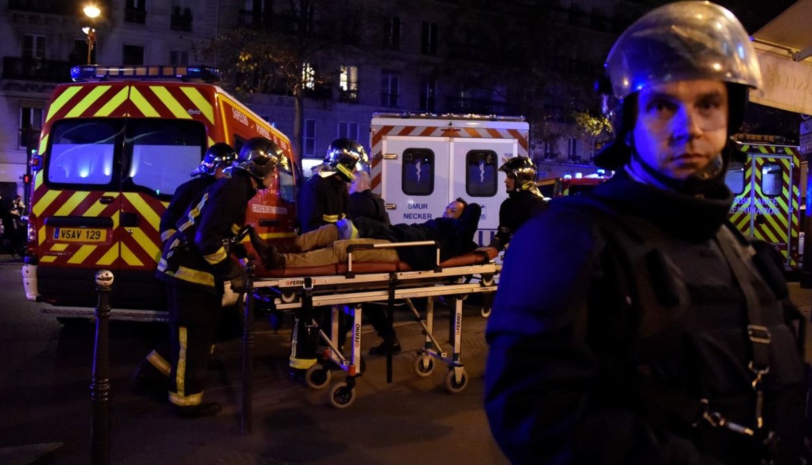 مسعفون ينقلون جريحا بالقرب من قاعة باتاكلان في وسط باريس، بعد سلسلة هجمات منسقة في باريس (14 ت2 2015، أ ف ب). 