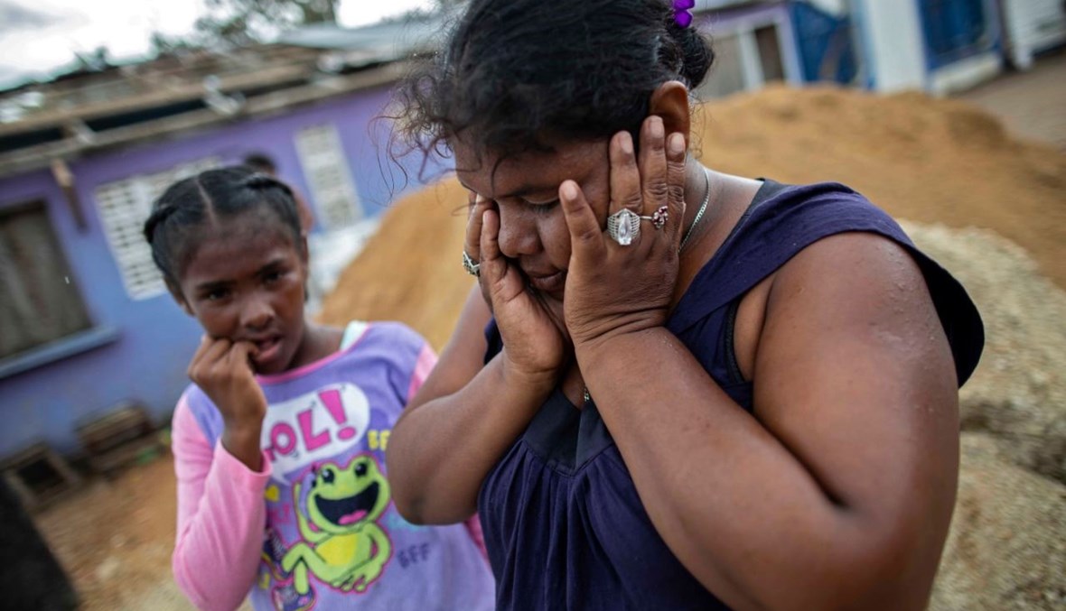 امرأة تنتظر مع ابنتها إجلاءهما من منطقة كاراتا إلى بيلوي في بويرتو كابيزاس بنيكاراغوا (15 ت2 2020، أ ف ب). 