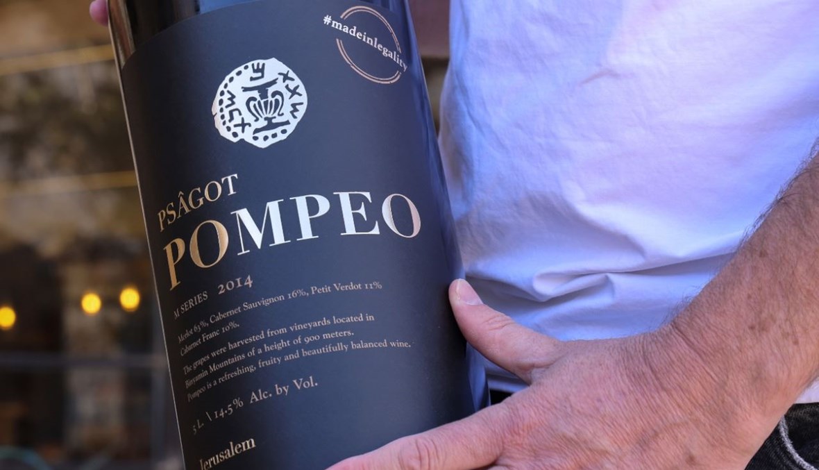 بيرغ يحمل قنينة من نبيذ "بومبيو" في مصنع نبيذ بساغوت بالقرب من مستوطنة بساغوت الإسرائيلية في الضفة الغربية المحتلة (18 ت2 2020، ا ف ب). 