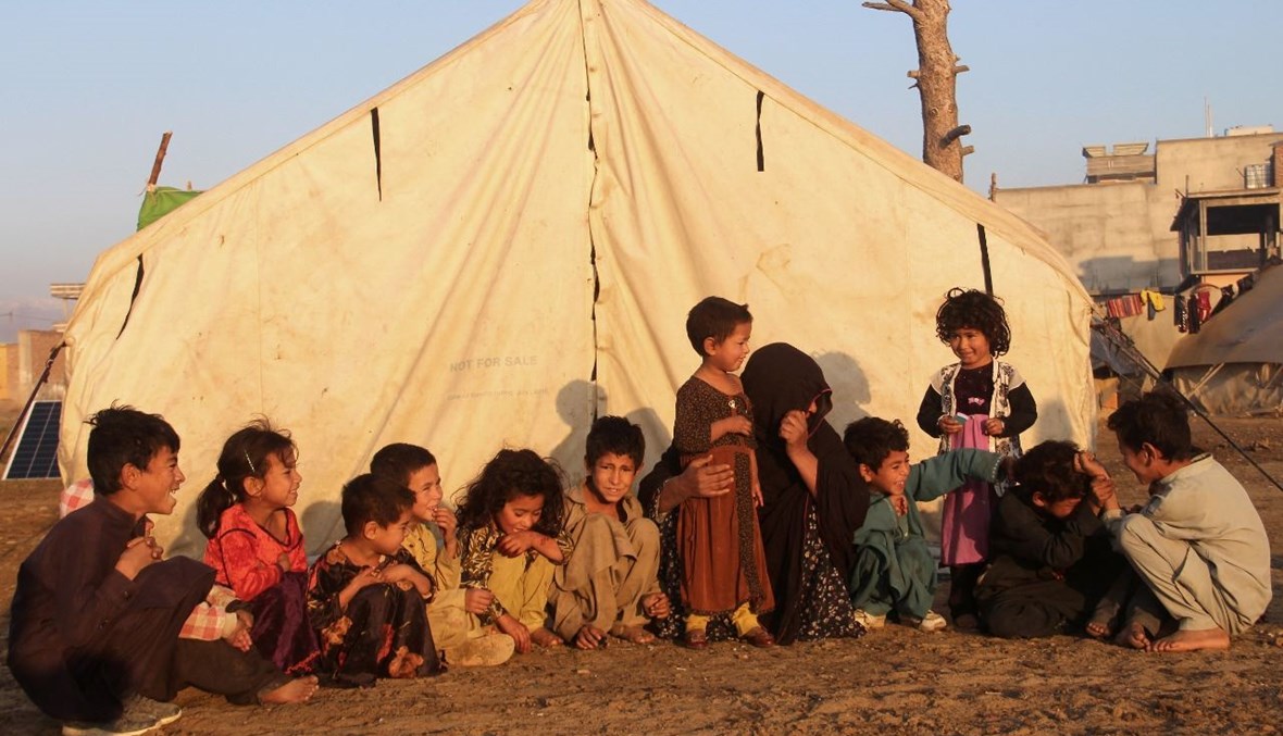 أطفال نازحون جلسوا خارج خيمة في مخيم للاجئين في محافظة خوست (17 ت2 2020، أ ف ب). 