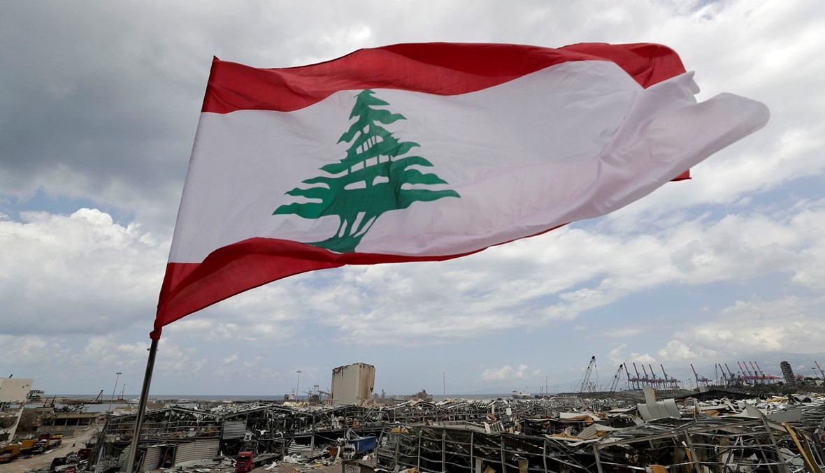 العلم اللبناني مرفوعًا وسط ركام بيروت