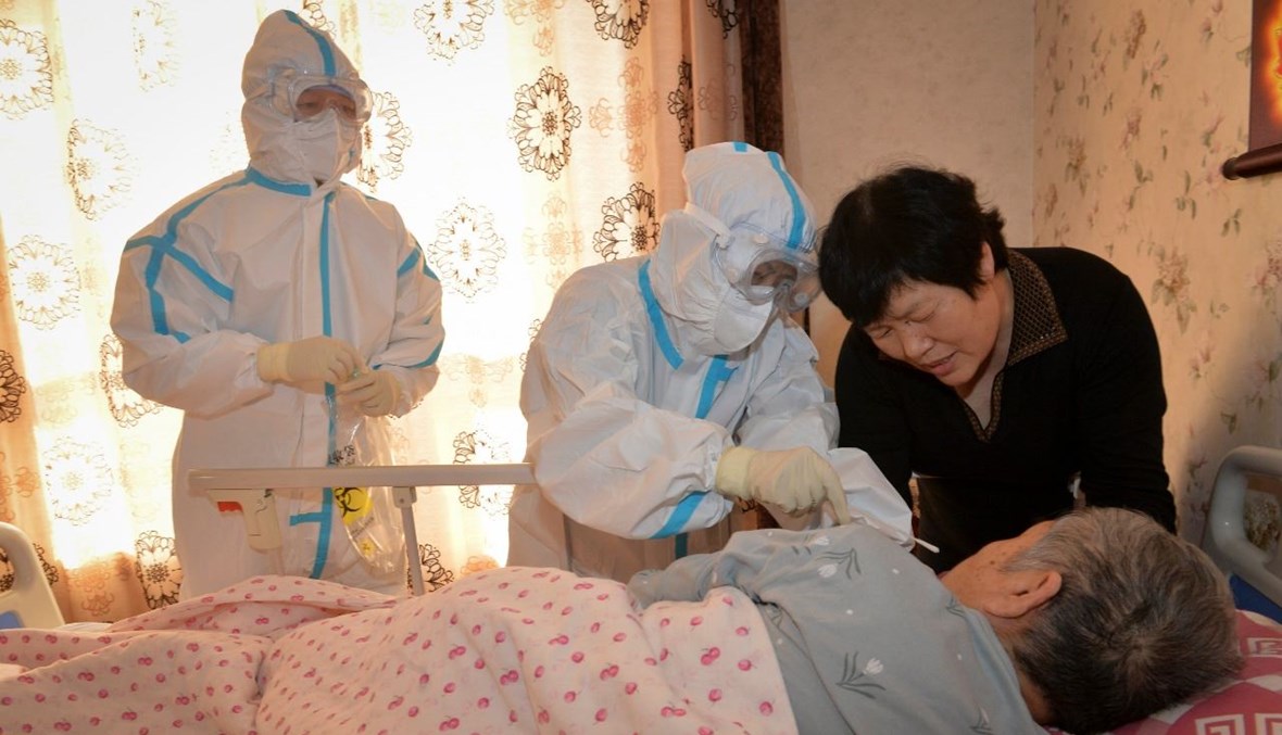 عامل طبي يأخذ مسحة من أحد السكان في منزله في تيانجين بالصين (22 ت2 2020، أ ف ب).  