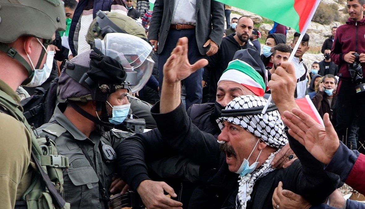 فلسطينيون خلال مواجهة مع قوات الأمن الإسرائيلية في أعقاب تظاهرة ضد التوسع الاستيطاني بالقرب من قرية بيت دجن شرق مدينة نابلس بالضفة الغربية المحتلة (20 ت2 ، أ ف ب). 