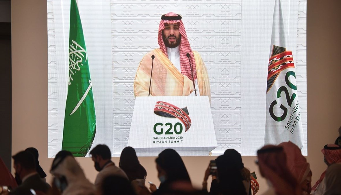 ممثلو وسائل الإعلام السعودية والأجنبية يستمعون إلى ولي العهد السعودي الأمير محمد بن سلمان يلقي كلمة عن بُعد في مؤتمر صحافي، في المركز الإعلامي لقمة مجموعة العشرين في الرياض (22 ت2 2020، أ ف ب). 