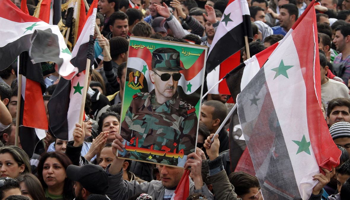 تظاهرة لسوريين مناصرين للنظام ولبشار الأسد في دمشق ("أ ف ب"- كانون الأول 2011).