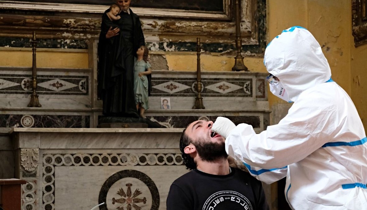عامل صحي يأخذ مسحة من رجل في كنيسة وسط نابولي (23 ت2 2020، أ ف ب). 