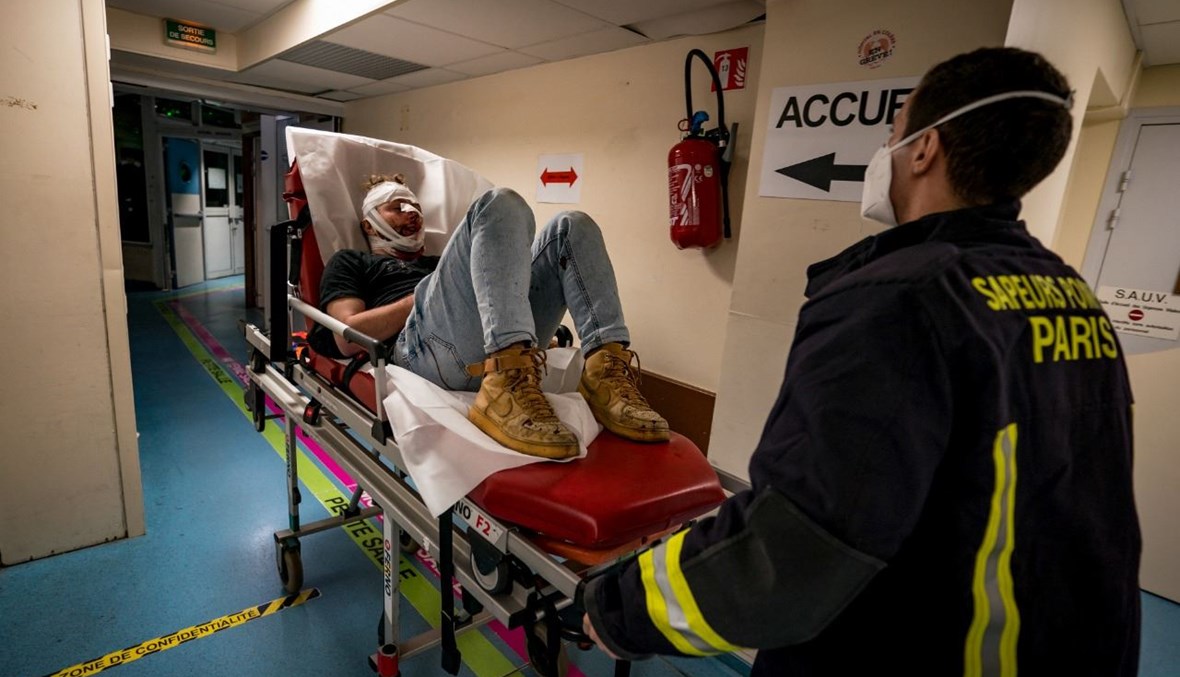 رجل اطفاء ينقل الحلبي بعد التعرض له في باريس (28 ت2 2020، أ ف ب). 