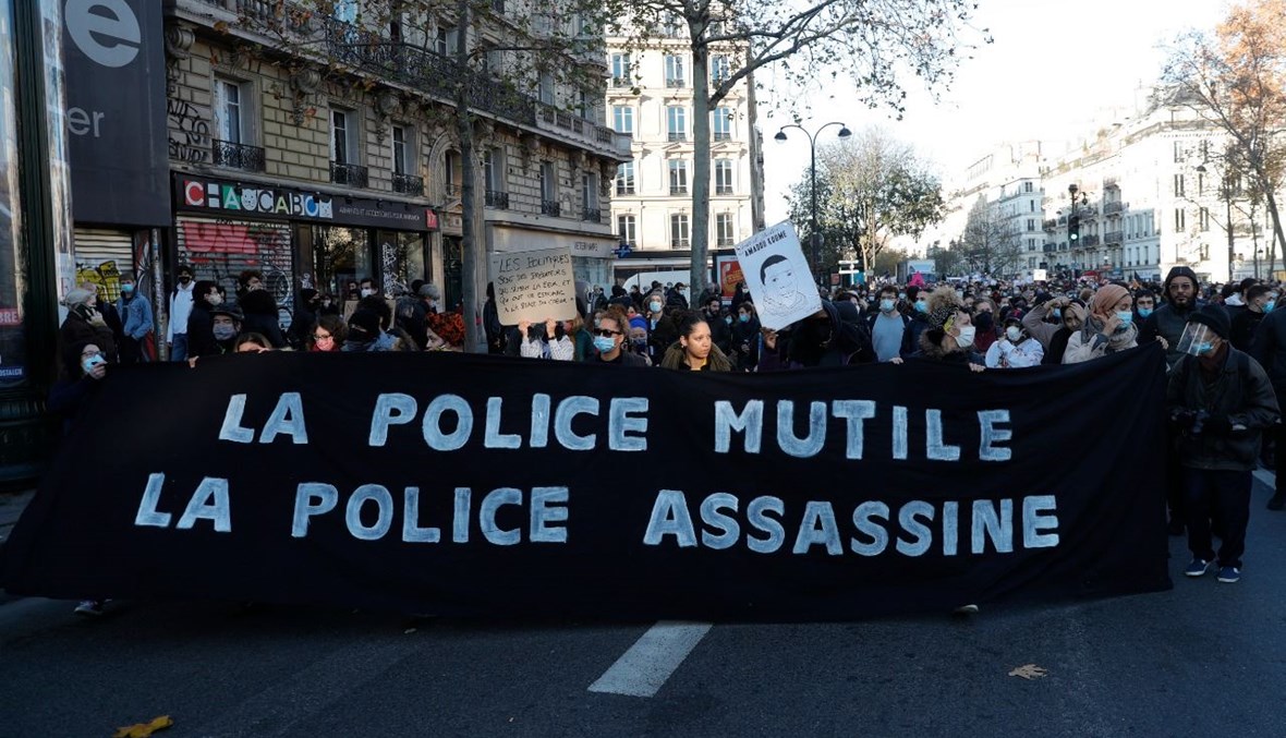متظاهرون يحملون لافتة مناوئة للشرطة في ساحة الجمهورية في باريس خلال احتجاج على مشروع قانون حول الأمن (28 ت2 2020، أ ف ب). 