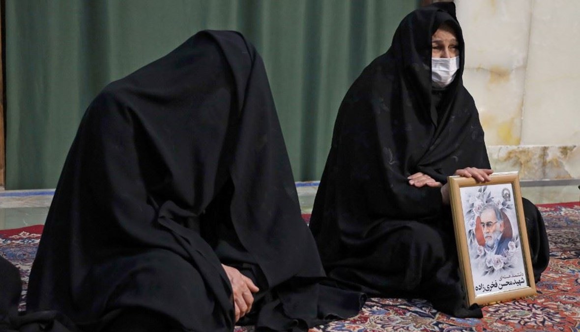 مشيعون يحملون صورة العالم النووي الإيراني محسن فخري زادة عند ضريح الإمام الرضا في مدينة مشهد أمس.    (أ ف ب)