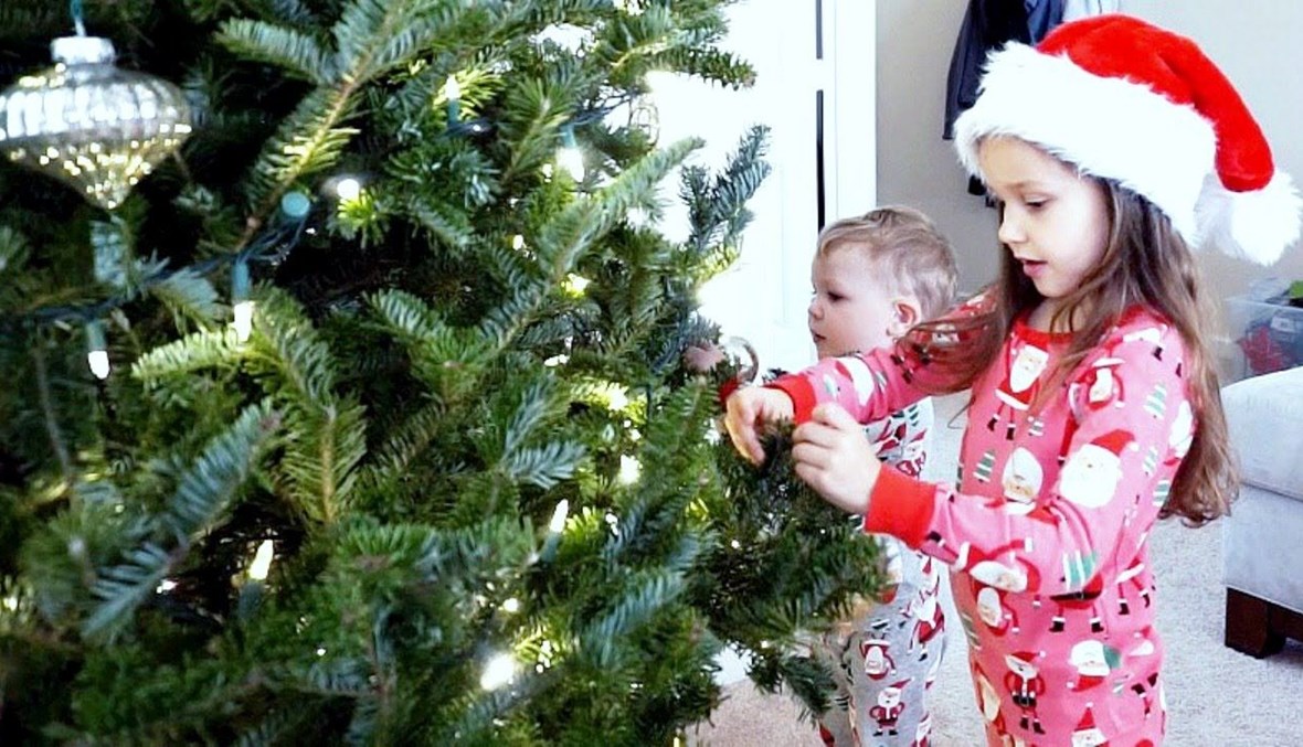 طفلة تزيّن شجرة الميلاد.