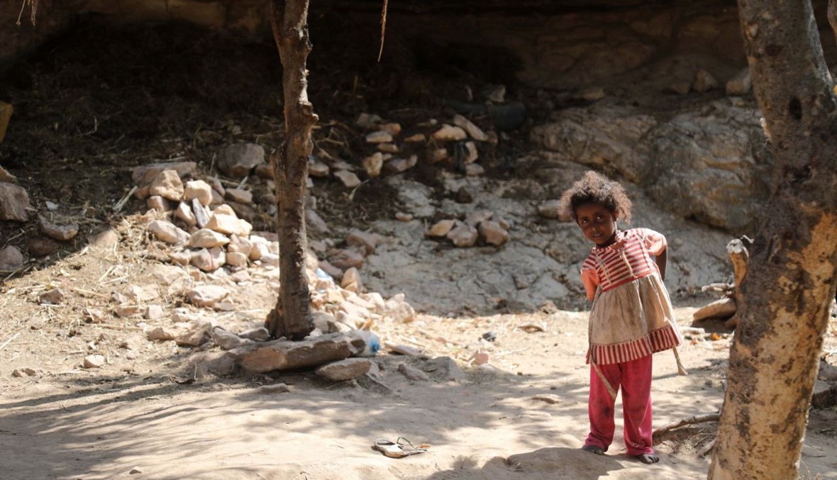 طفل يقف خارج كهف لجأت إليه عائلة يمنية بسبب الفقر ونقص السكن، غرب ضواحي مدينة تعز في اليمن (2 ك1 2020، أ ف ب). 