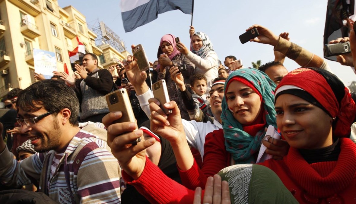 صورة أرشيفية- مصريون يستخدمون هواتفهم المحمولة لتصوير الاحتفالات في ميدان التحرير بالقاهرة (12 شباط 2011، أ ف ب). 