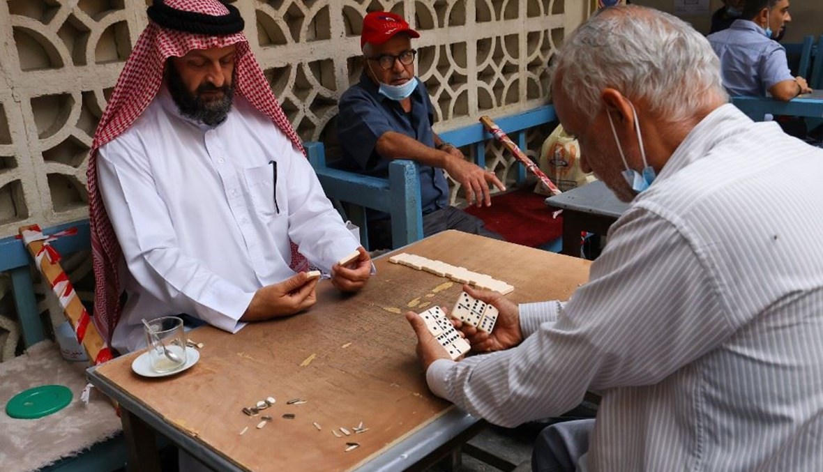 بحرينيون يلعبون الدومينو في مقهى بالسوق القديم في المنامة الثلثاء.   (أ ف ب)