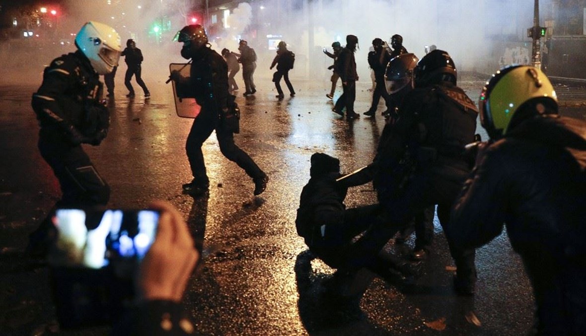الشرطة الفرنسية تعتقل متظاهراً خلال احتجاجات في باريس أمس.   (أ ف ب)
