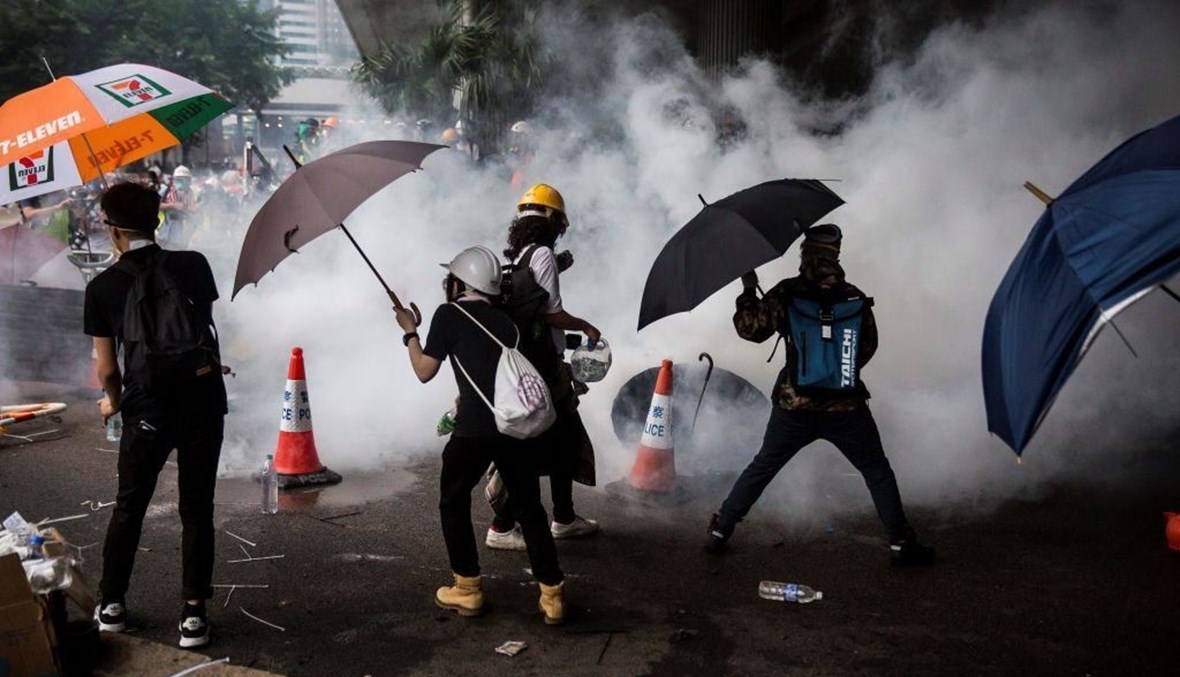 متظاهرون في هونغ كونغ في مواجهة القنابل المسيلة للدموع (أ ف ب).