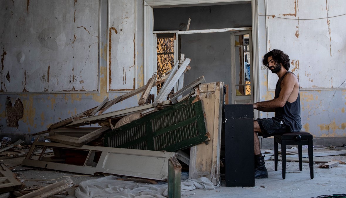 ريمون أسايان يعزف على البيانو في مبنى مدمّر.