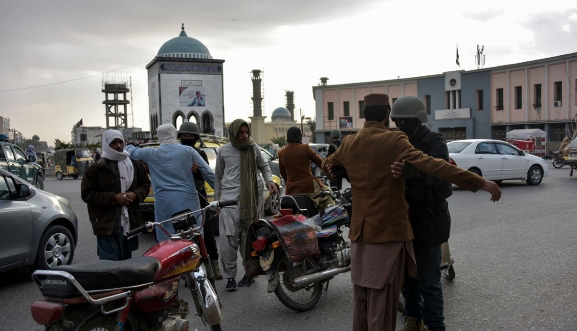 عناصر من الشرطة الأفغانية يفتشون الناس عند نقطة تفتيش في تشوك شاهيدان في قندهار (13 ك1 2020، أ ف ب).