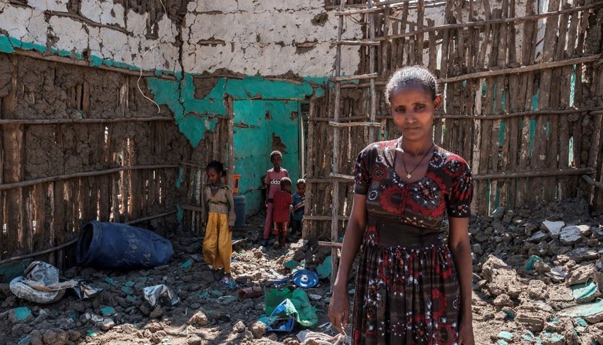 امرأة وأولادها وسط ركام منزلهما المدمر في قرية بيسوبر بإقليم تيغراي الأثيوبي.(أ ف ب)