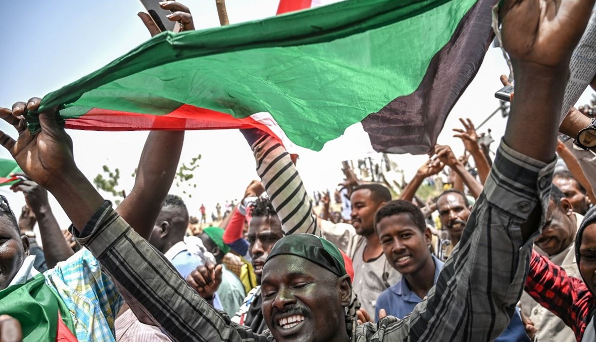  سودانيون يرددون هتافات خلال تظاهرة خارج مجمع الجيش في العاصمة الخرطوم (18 نيسان 2019، أ ف ب). 
