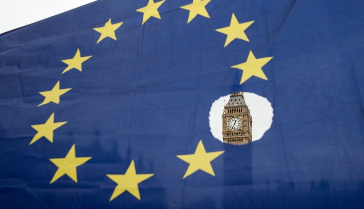 متظاهر معارض لبريكست حمل علم الاتحاد الأوروبي، وبدا في الخلفية مقر مجلس البرلمان في لندن (29 آذار 2017، أ ف ب). 