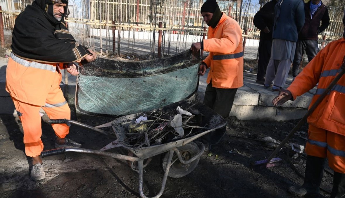 عمال البلدية يزيلون الأضرار في أحد الشوارع بعد إطلاق صواريخ عدة على كابول (12 ك1 2020، أ ف ب).