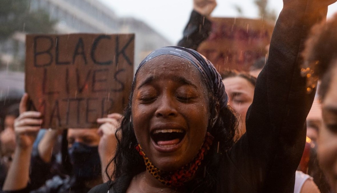 متظاهرة تهتف "حياة السود مهمة" أمام بارك لافاييت بجوار البيت الأبيض بواشنطن خلال طقس ماطر (5 حزيران 2020، أ ف ب).