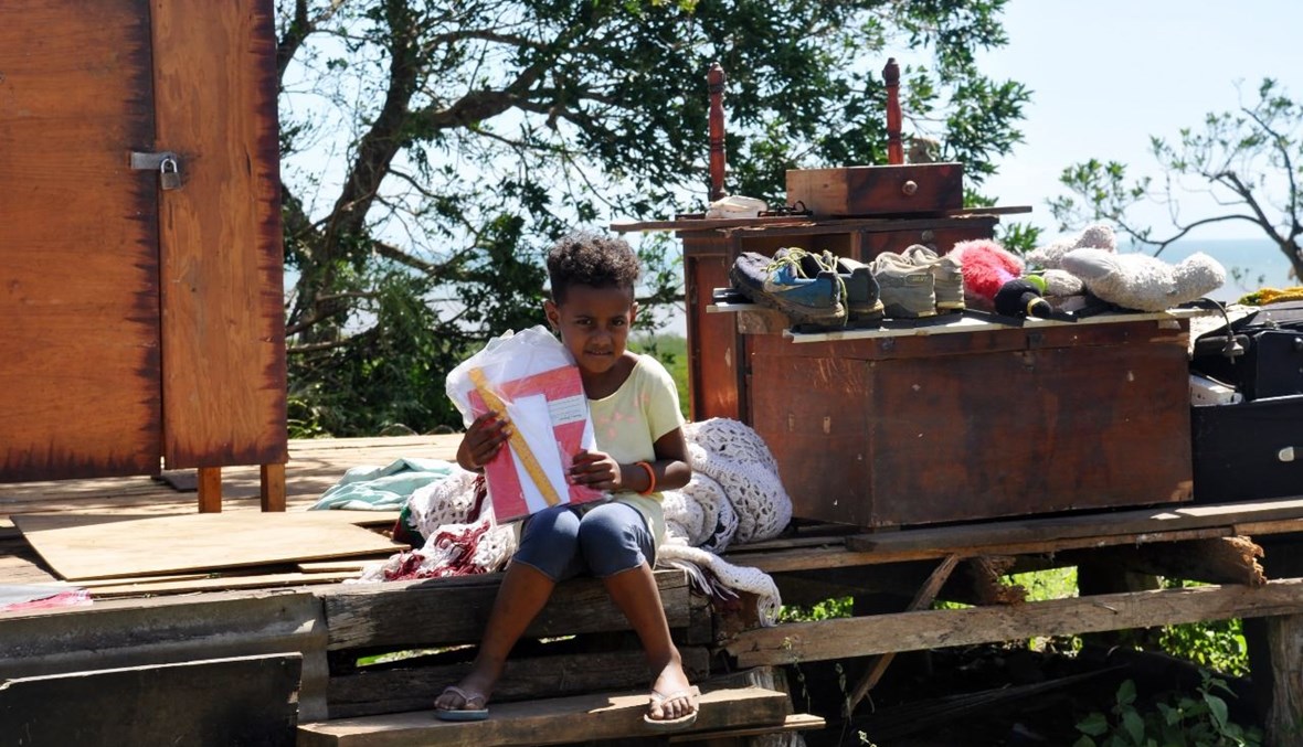 طفل جلس أمام منزله المدمر من جراء الإعصار ياسا، في شمال بوا في جزيرة فانوا ليفو في فيجي (20 ك1 2020، أ ف ب). 
