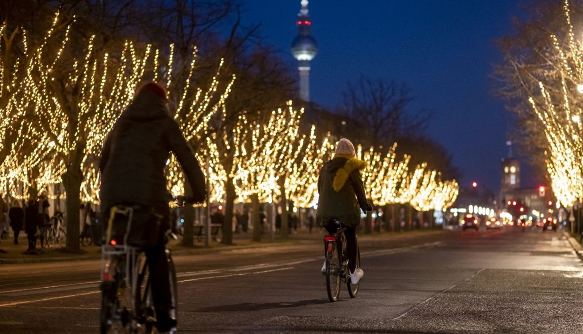 شخصان يركبان الدراجة في شارع أونتر دن ليندن في برلين (19 ك1 2020، أ ف ب). 