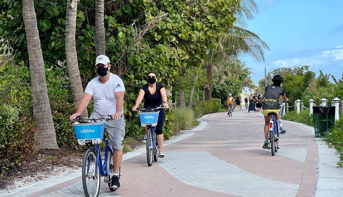 أشخاص يركبون الدراجة بالقرب من الشاطئ في ميامي بفلوريدا (20 ك1 2020، أ ف ب). 