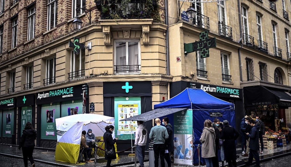أشخاص انتظروا بالصف امام صيدلية في منطقة تجارية وسط باريس لإجراء اختبار سريع لكورونا (23 ك1 2020، أ ف ب). 