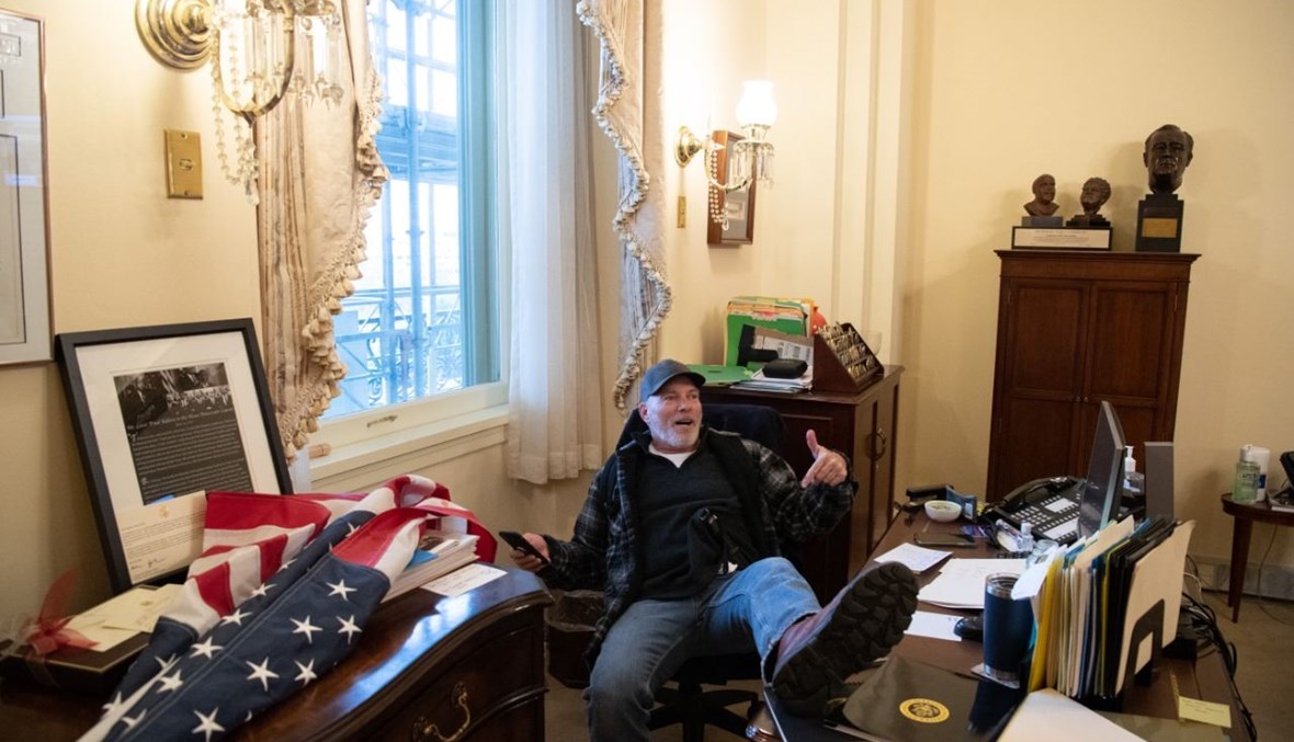 ريتشارد بارنيت، أحد أنصار ترامب، يجلس داخل مكتب بيلوسي في مبنى الكابيتول في واشنطن (6 ك2 2021، أ ف ب).