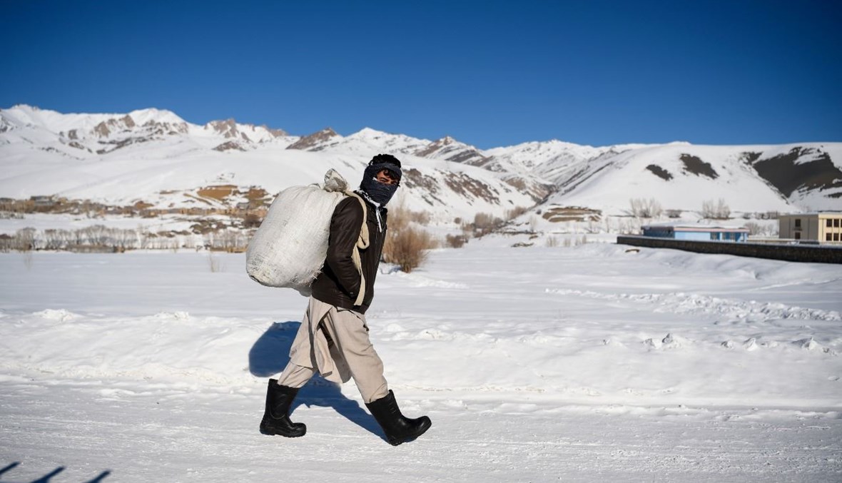 رجل من الهزارة يمشي على طريق غطتها الثلوج في ميدان وردك (9 ك2 2021، أ ف ب).