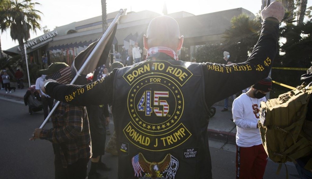 أشخاص مؤيدون للرئيس الاميركي دونالد ترامب يرفعون أعلاماً خلال مشاركتهم في "المسيرة الوطنية" بسان ييغو بولاية كاليفورنيا السبت. (أ ف ب) 