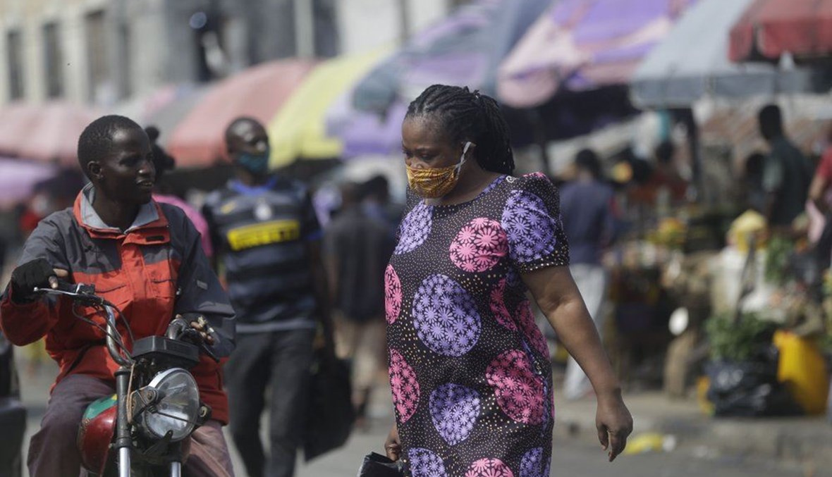 امرأة تمشي في أحد الأسواق في لاغوس بنيجيريا (24 ك1 2020، أ ب).