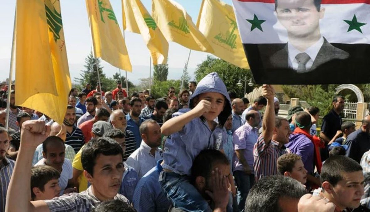 صورة لمناصري "حزب الله" يرفعون صورة الأسد.